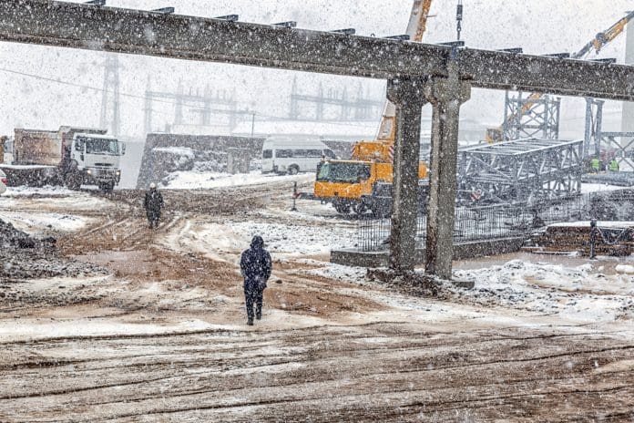 View of the construction site with snowy weather. Construction is a general term meaning the art and science to form objects, systems, or organizations. Travis Perkins shares tips on cold-weather construction