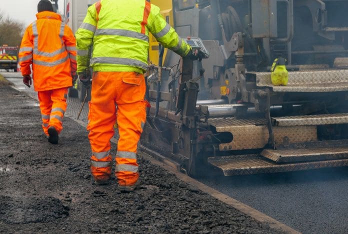 Two construction workers carrying our roadworks laying new asphalt Wrekin discusses the evolving needs of UK roads