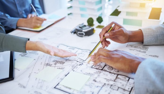 Hands of architecture blueprint design, 3d property construction building and engineering model planning. Creative team collaboration on floor plan sketch, drawing development and industrial project How design firms can maximise A&E profits with smarter resource planning