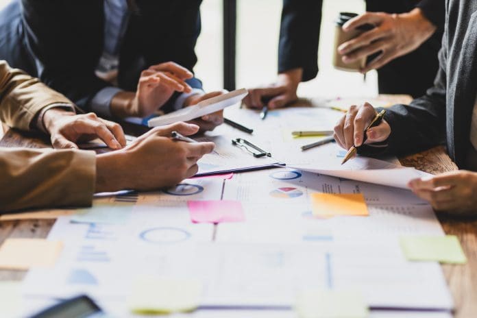 Brainstorm business meeting to discuss analysis of financial figures, graphs and growth charts of business investments to plan new business projects. Early planning in construction has a positive impact on project culture
