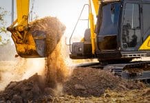 Construction won’t solve its skills crisis by looking in the rear-view mirror Close-up of excavator at construction site. Backhoe digging soil for earthwork and construction business. Excavating machine at work. Heavy machinery for earth moving and construction site development