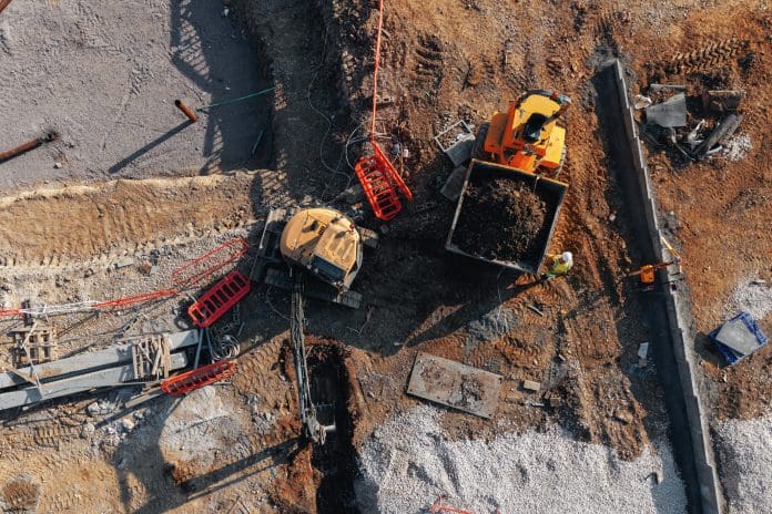 Aerial view from drone at excavator and dumper busy at construction site The Building Safety Levy is considered by many to be anti-growth
