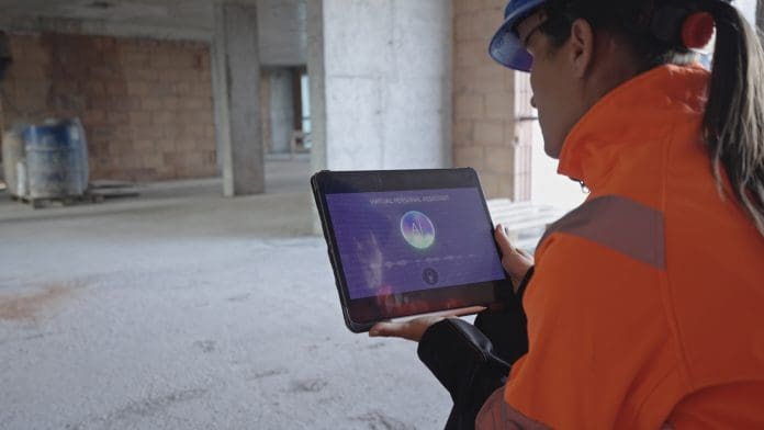 Woman Technical Supervisor Works With Multimodal AI Virtual Assistant On Construction Site How small contractors can win work without investing in AI