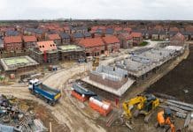 Planning reform will decide whether the UK housing recovery lasts Aerial view above a construction site building new and affordable eco friendly houses with solar panels in the UK on green belt land
