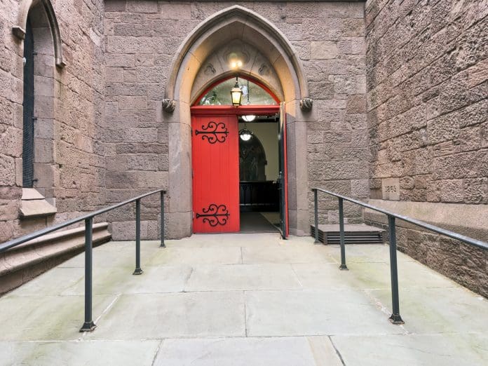Historic Church Entrance with Gothic Arch and Wooden Door Open Heritage site revamp needs to balance ups and downs of accessibility