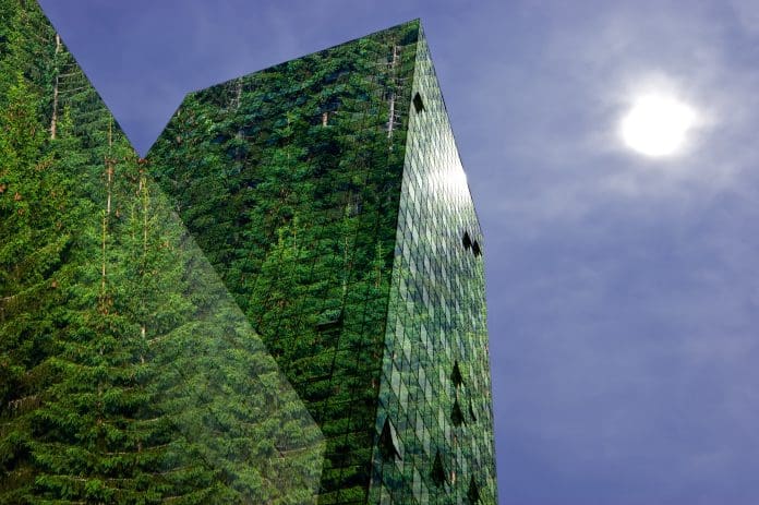 Green energy in the city Green, renewable energy in the city: modern building covered with spruce forest. Sustainable energy, pollution and urbanity concept with copy space.