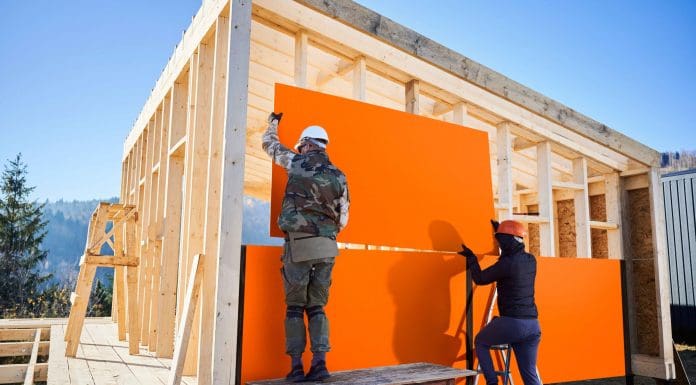 wood-based panels being placed onto a timber frame house